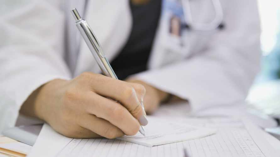 Female doctor writing prescription