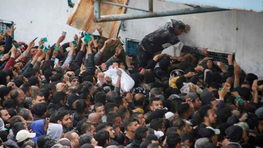 Палестинцы собираются, чтобы получить помощь возле склада БАПОР в городе Газа, 18 марта /Фото: REUTERS