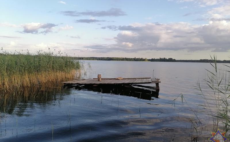 Рыбак находился на деревянной кладке на берегу озера.