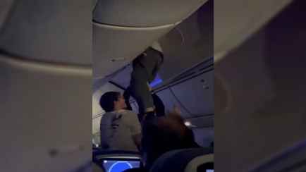 На видео попало, как пассажир самолёта, угодившего в зону турбулентности, застрял в багажной полке
