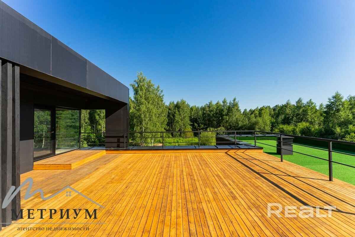 Tesla — в подарок. Под Минском выставили на продажу чёрный дом в футуристическом стиле. Сколько просят?