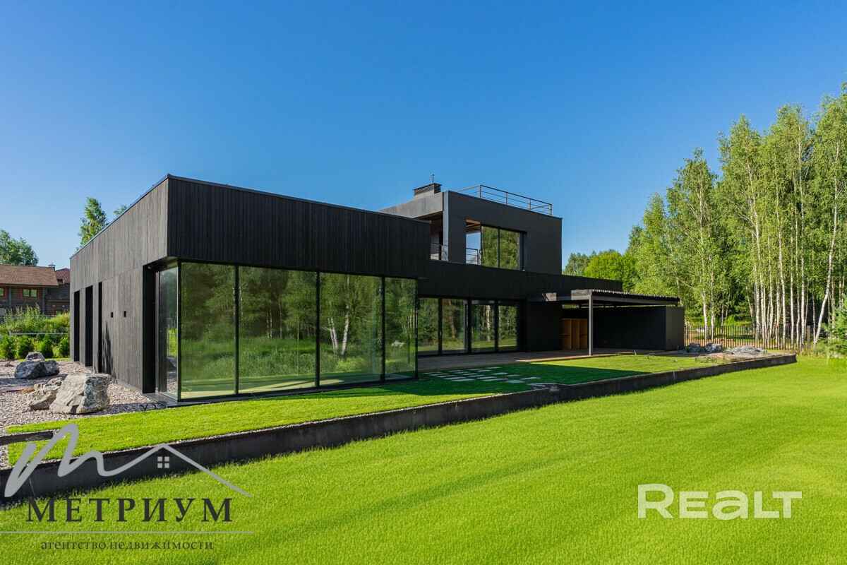 Tesla — в подарок. Под Минском выставили на продажу чёрный дом в футуристическом стиле. Сколько просят?