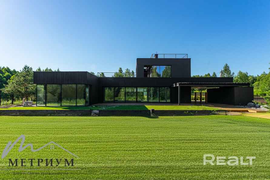 Tesla — в подарок. Под Минском выставили на продажу чёрный дом в футуристическом стиле. Сколько просят?