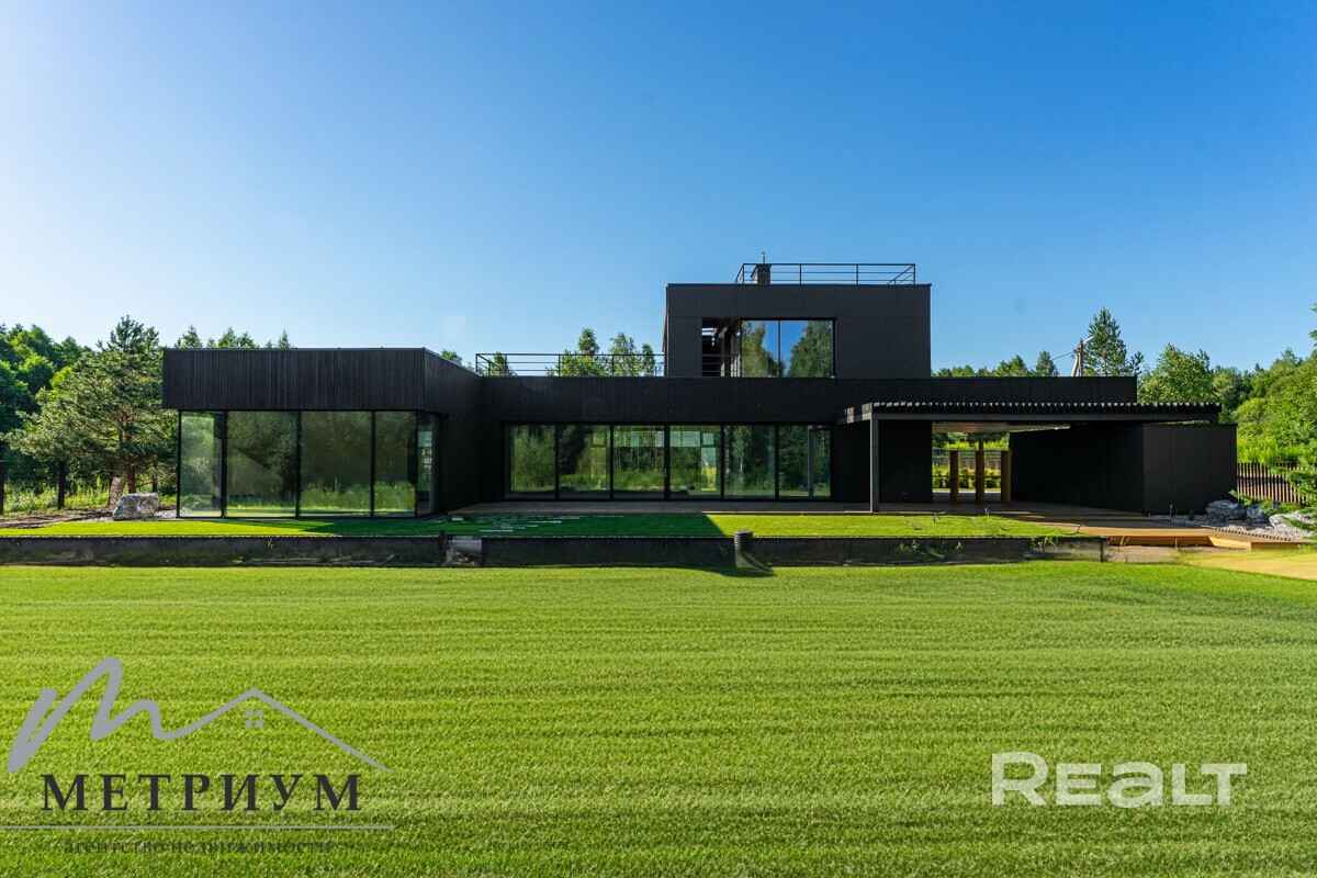 Tesla — в подарок. Под Минском выставили на продажу чёрный дом в футуристическом стиле. Сколько просят?