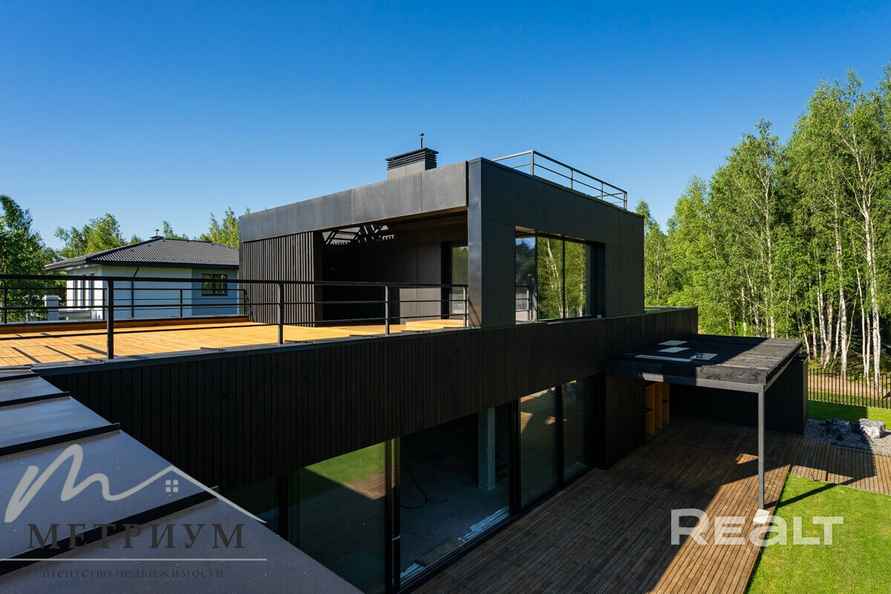 Tesla — в подарок. Под Минском выставили на продажу чёрный дом в футуристическом стиле. Сколько просят?