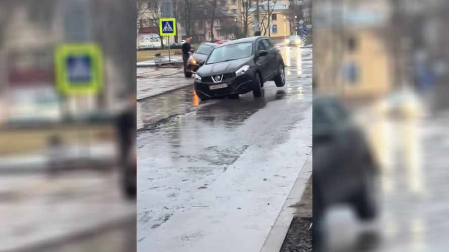 На видео попало, как две легковушки провалились в яму посреди улицы в Минске
